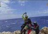 Dozens saved by Italy from migrant shipwrecks; some, clinging to rocks, plucked to safety by copters
