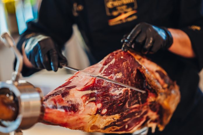 a-person-cutting-meat-with-a-knife-description-au A person cutting meat with a knife Description automatically generated